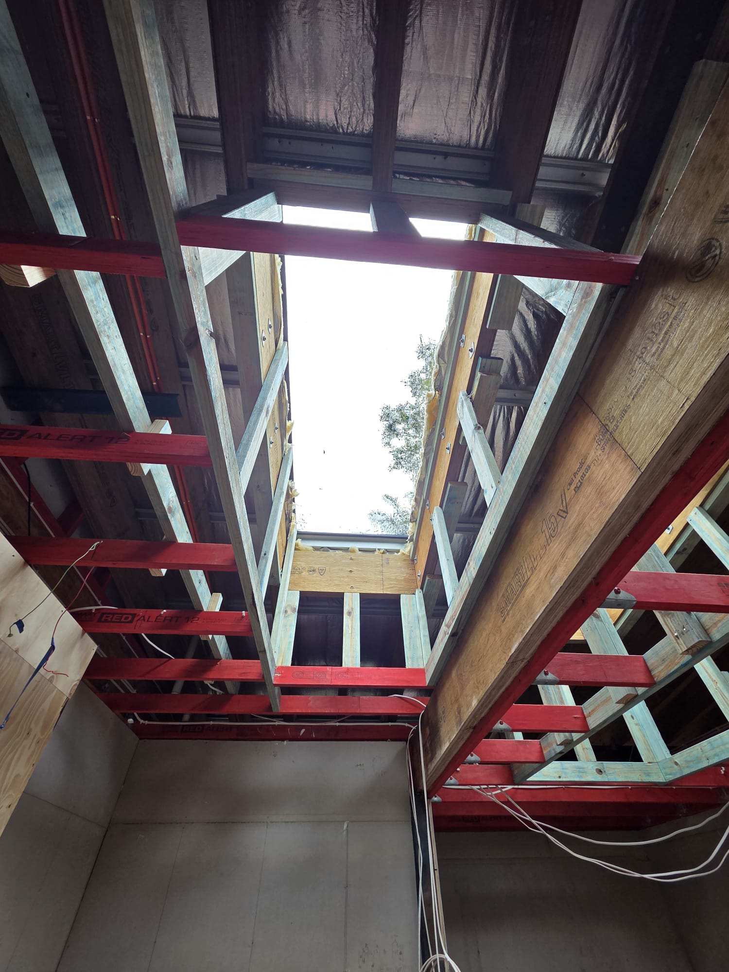 Framed roof opening for a skylight installation, viewed from inside a home.