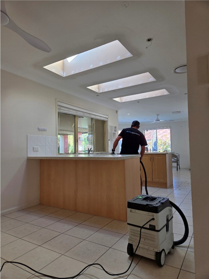 Three skylight shafts in a kitchen and living ceiling, with an installer working at the bench below.