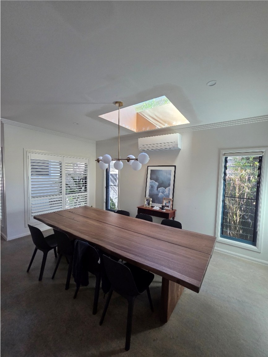 Square skylight above a dining table with a pendant light.