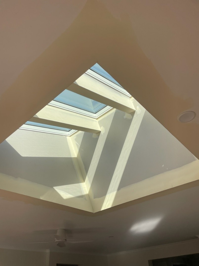 Wide plasterboard skylight shaft in a raked ceiling, seen from directly below.