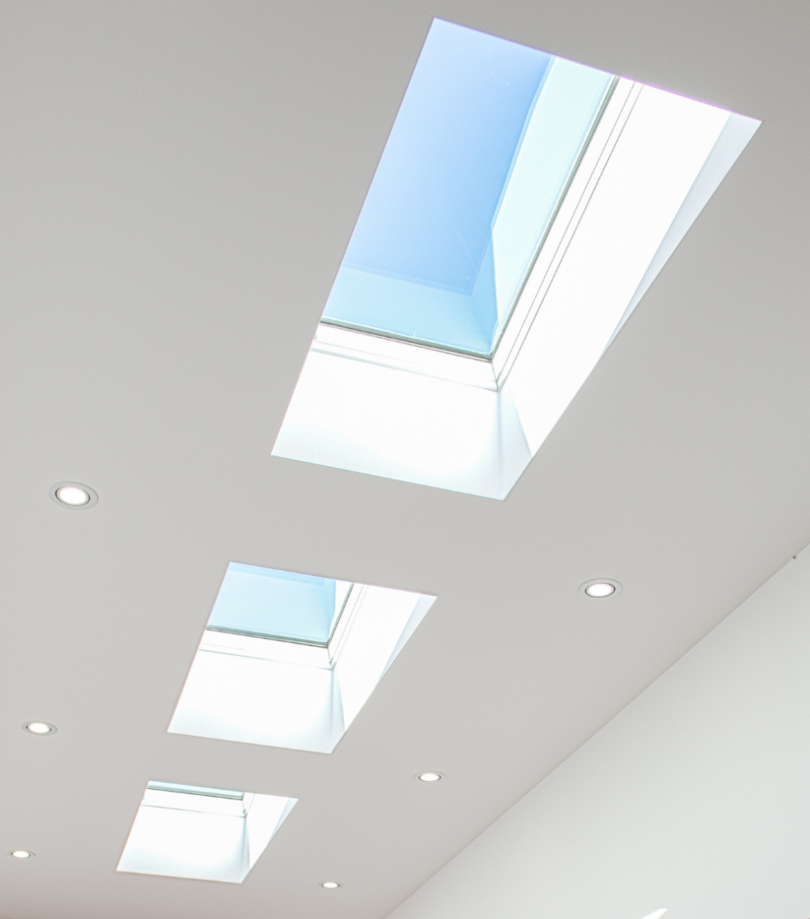 Multiple skylights arranged in a row along a white ceiling