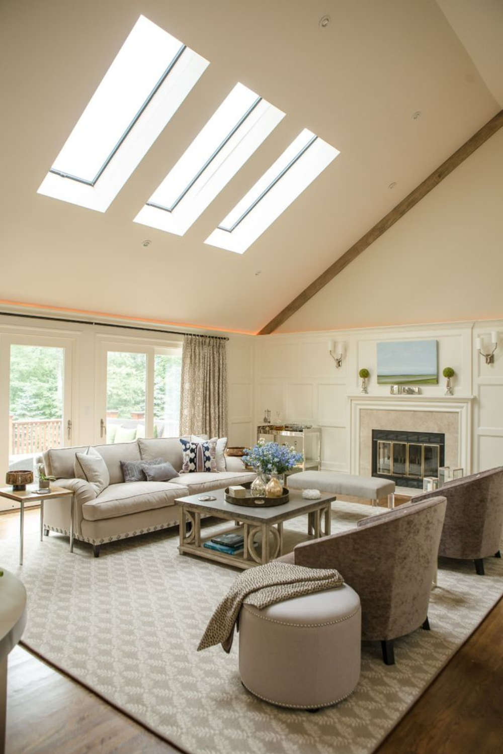 A light living room with daylight arriving from three skylights set into a raked ceiling